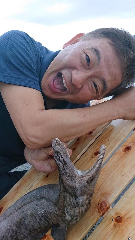 ラブカを抱えて笑う石垣幸二